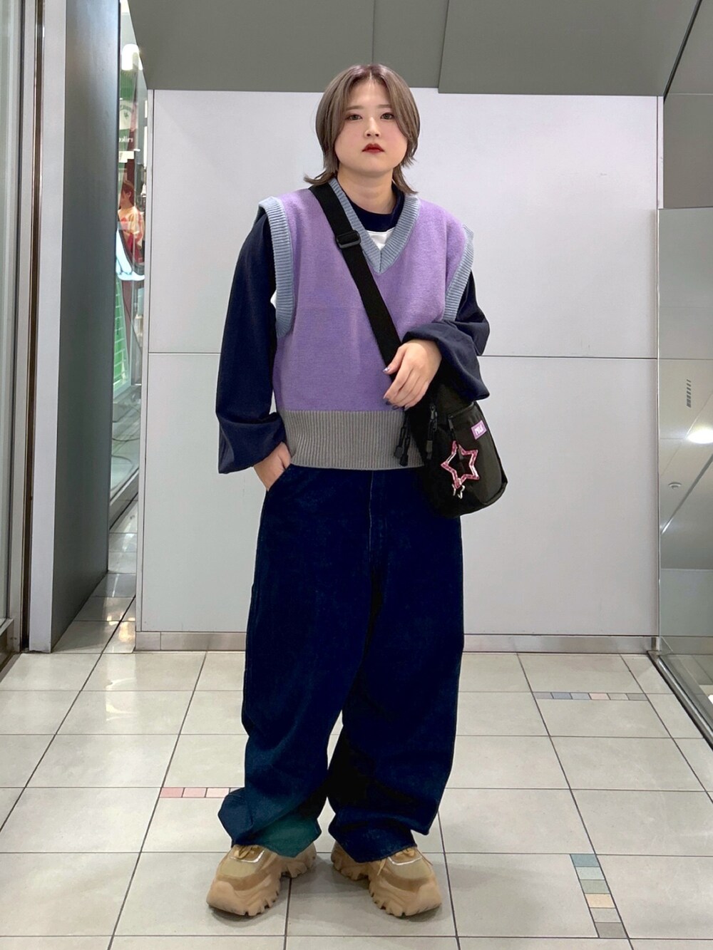 パープル系のベスト、ホワイト系のTシャツ/カットソー、パープル系のショルダーバッグを着用したレディースの秋コーディネートの2枚目の写真