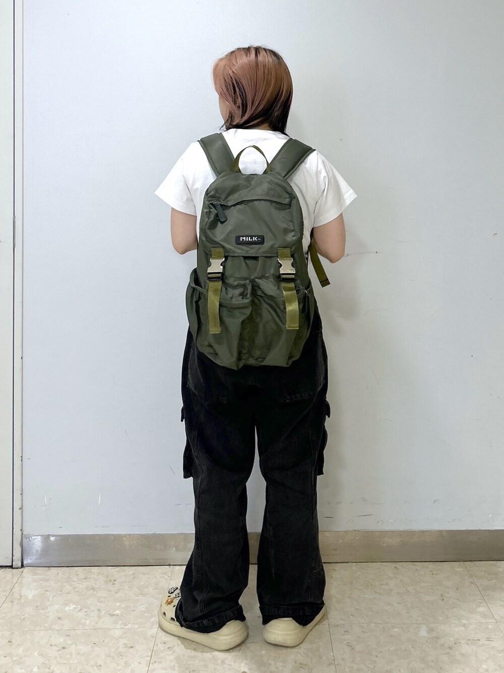 ベージュ系のサンダル、グリーン系のバックパック/リュック、ホワイト系のTシャツ/カットソーを着用したレディースの夏コーディネートの6枚目の写真