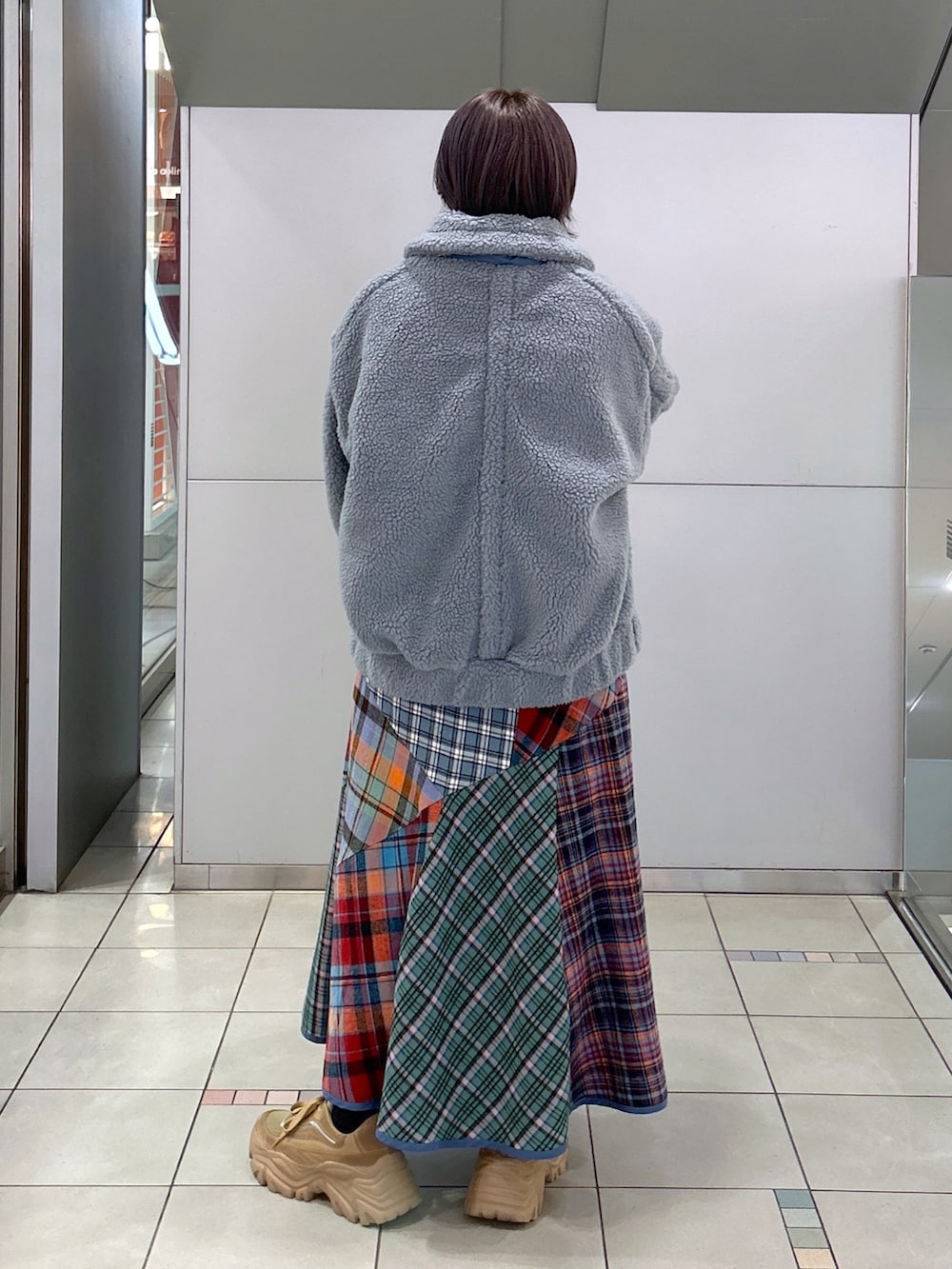 ブラック系のボストンバッグ、グリーン系のスカート、ベージュ系のスニーカーを着用したレディースの秋コーディネートの3枚目の写真