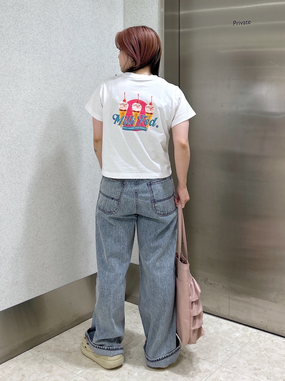 ブルー系のデニムパンツ、ピンク系のトートバッグ、ベージュ系のサンダルを着用したレディースの夏コーディネートの4枚目の写真