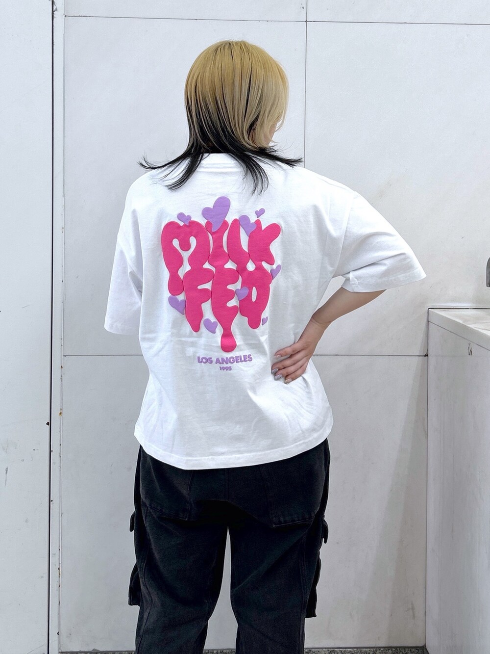 ブラック系のカーゴパンツ、ホワイト系のTシャツ/カットソー、ブラウン系のボストンバッグを着用したレディースの春コーディネートの4枚目の写真