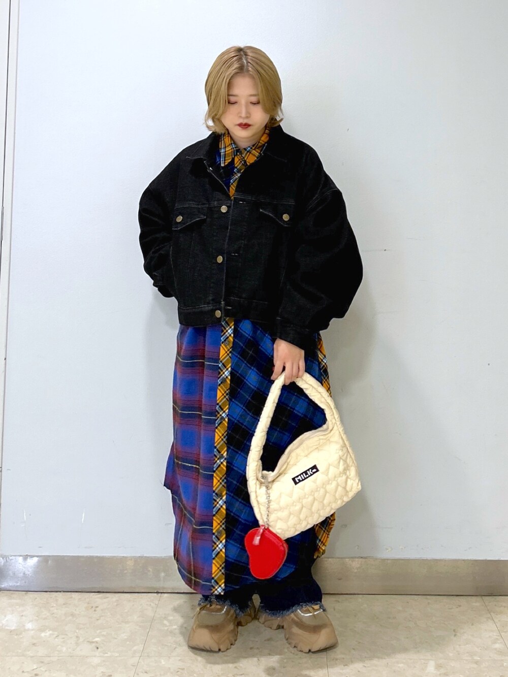 ブラック系のデニムジャケット、ブルー系のシャツワンピース、ホワイト系のハンドバッグを着用したレディースの秋コーディネートの2枚目の写真