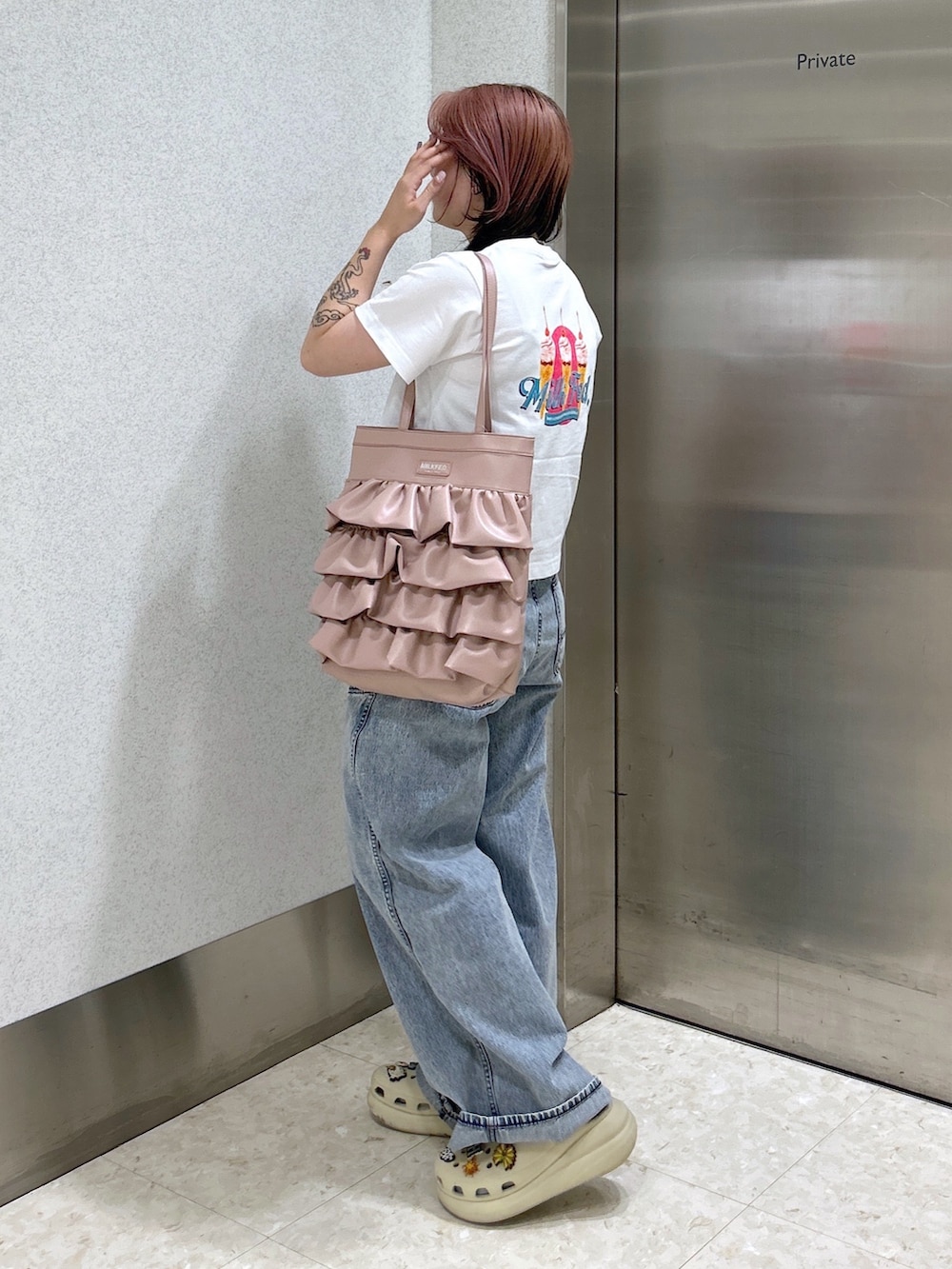 ブルー系のデニムパンツ、ピンク系のトートバッグ、ベージュ系のサンダルを着用したレディースの夏コーディネートの5枚目の写真