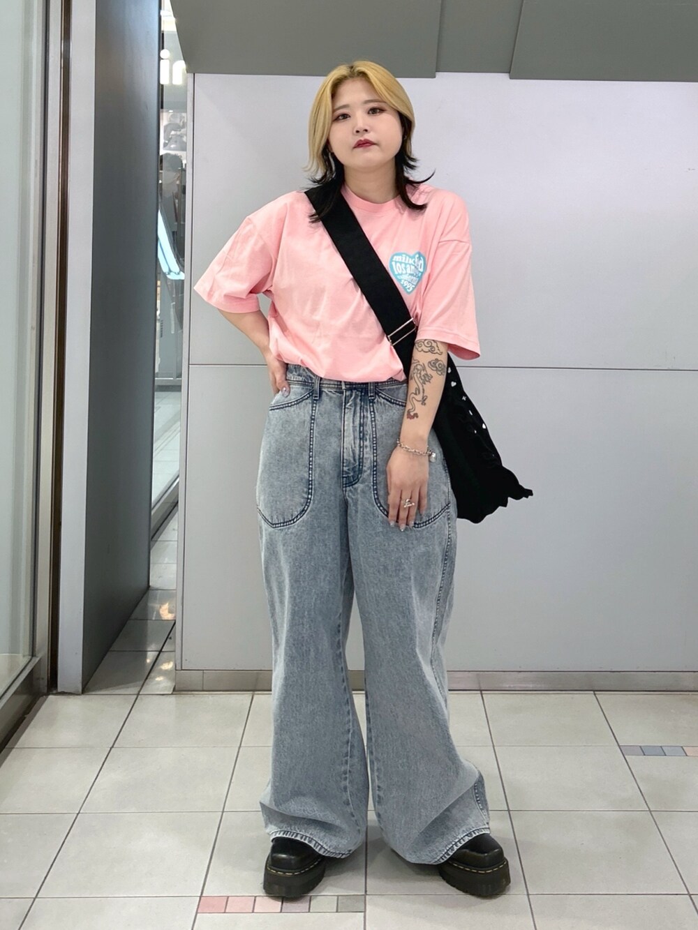 ピンク系のTシャツ/カットソー、ブルー系のデニムパンツ、ブラック系のショルダーバッグを着用したレディースの春コーディネートの2枚目の写真
