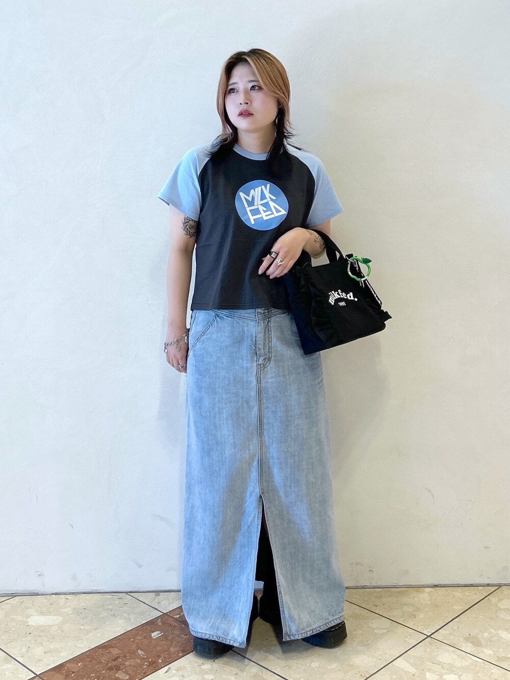 ブルー系のTシャツ/カットソー、ブラック系のショルダーバッグ、ブラック系のブーツを着用したレディースの夏コーディネートの2枚目の写真