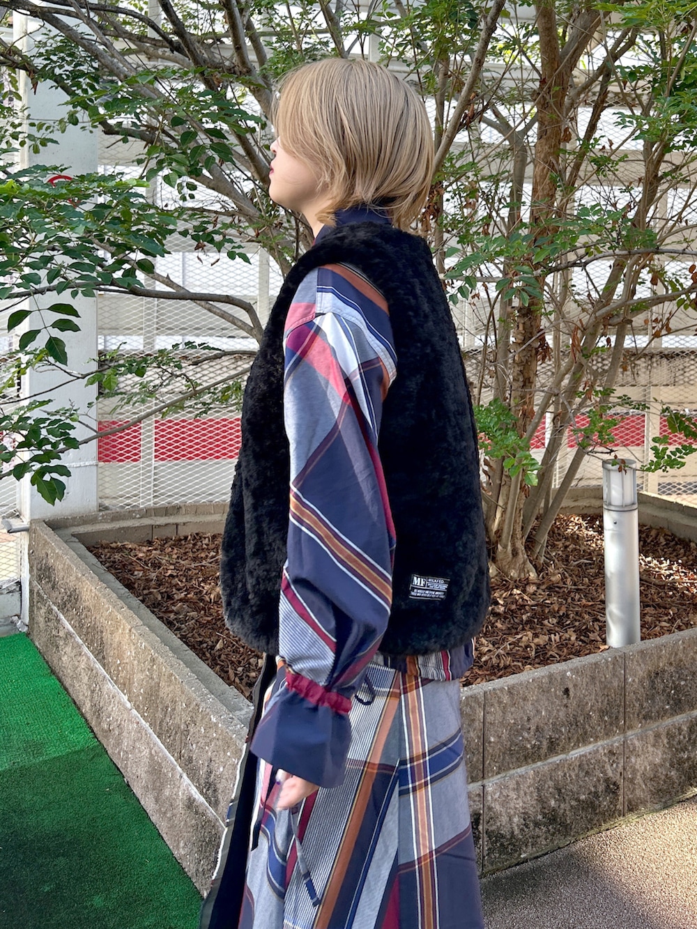 ブラック系のベスト、ブルー系のシャツ/ブラウス、ブルー系のスカートを着用したレディースの秋コーディネートの4枚目の写真