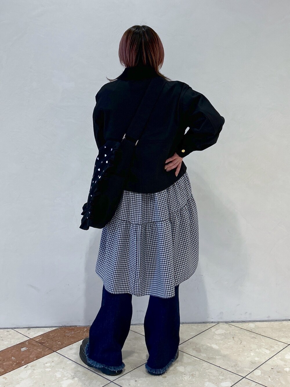 ブルー系のデニムパンツ、ブラック系のカバーオール、ブラック系のワンピースを着用したレディースの春コーディネートの4枚目の写真