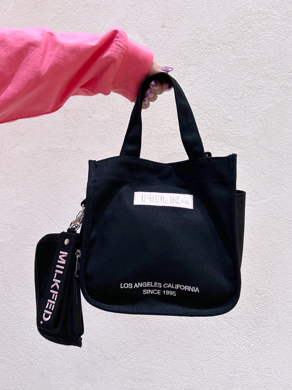 ピンク系のTシャツ/カットソー、ブラック系のデニムパンツ、ピンク系のショルダーバッグを着用したレディースの夏コーディネートの5枚目の写真