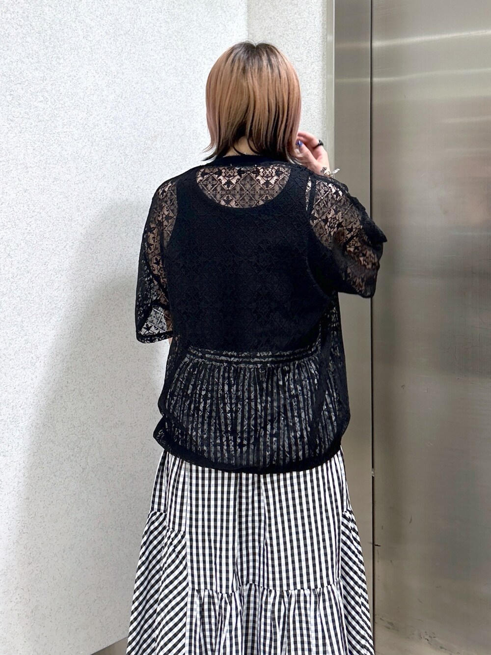 ブラック系のタンクトップ、ブラック系のTシャツ/カットソー、ブラック系のハンドバッグを着用したレディースの夏コーディネートの4枚目の写真