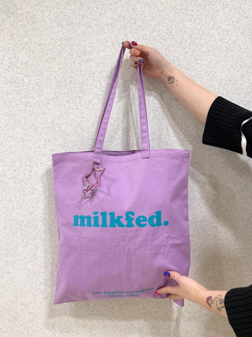 ベージュ系のサロペット/オーバーオール、パープル系のトートバッグ、ブラック系のカーディガン/ボレロを着用したレディースの春コーディネートの5枚目の写真