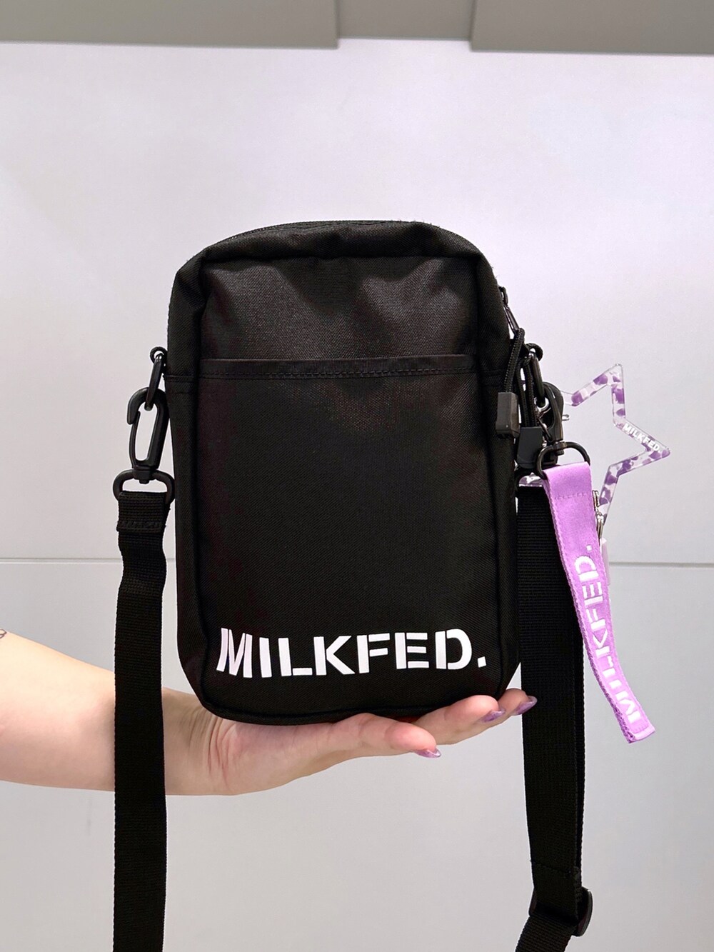 パープル系のTシャツ/カットソー、パープル系のショルダーバッグ、ホワイト系のスカートを着用したレディースの秋コーディネートの5枚目の写真