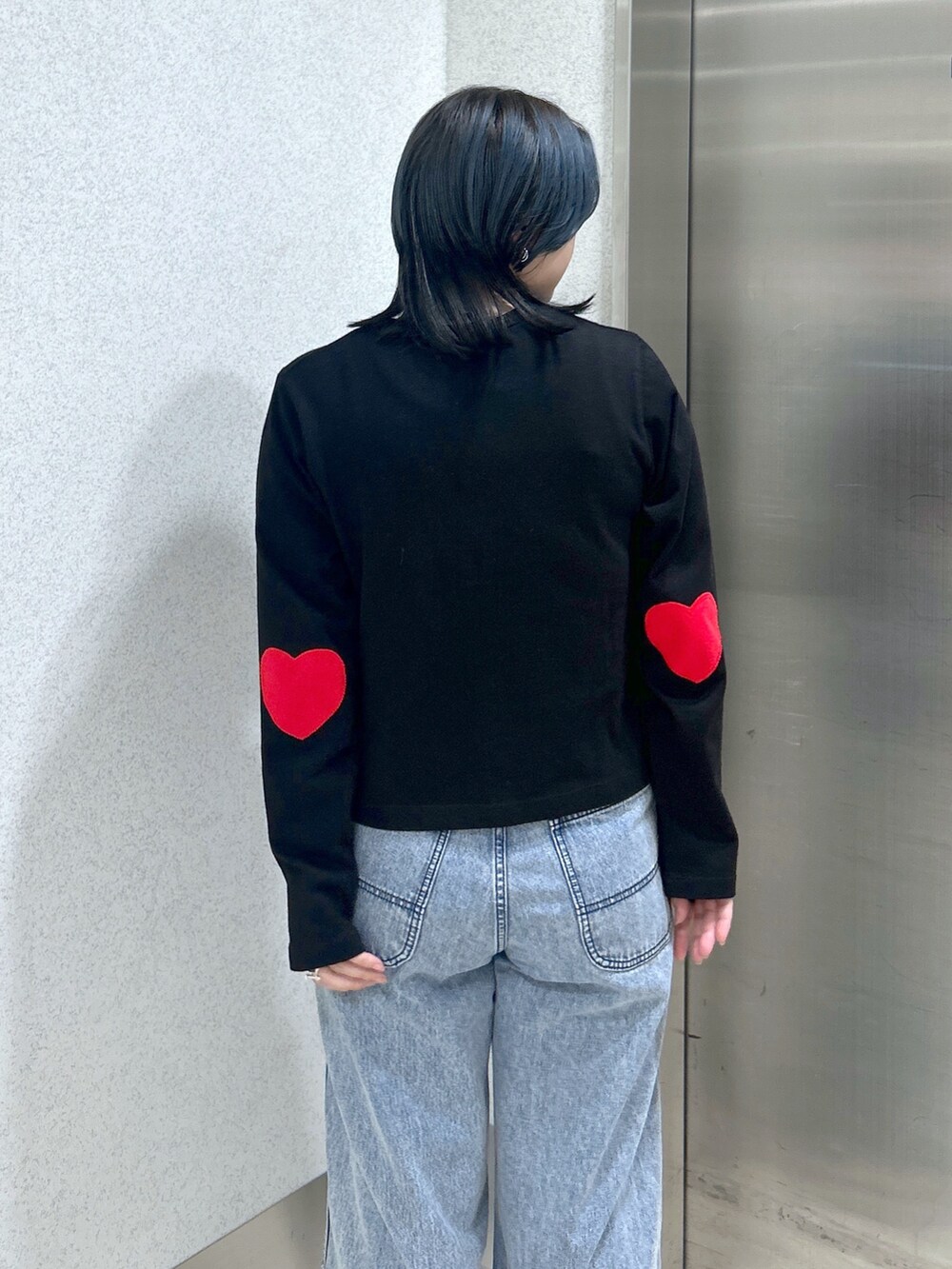 ブルー系のハンドバッグ、ブルー系のデニムパンツ、ベージュ系のサンダルを着用したレディースの夏コーディネートの8枚目の写真