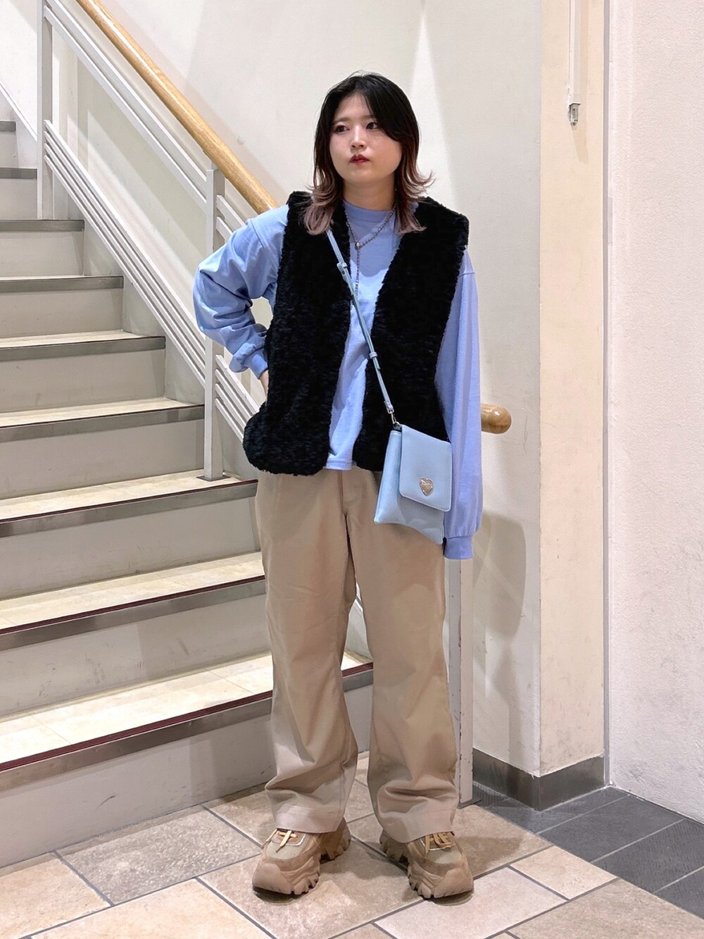 ブラック系のベスト、ブルー系のTシャツ/カットソー、ブルー系のショルダーバッグを着用したレディースの夏コーディネートの2枚目の写真