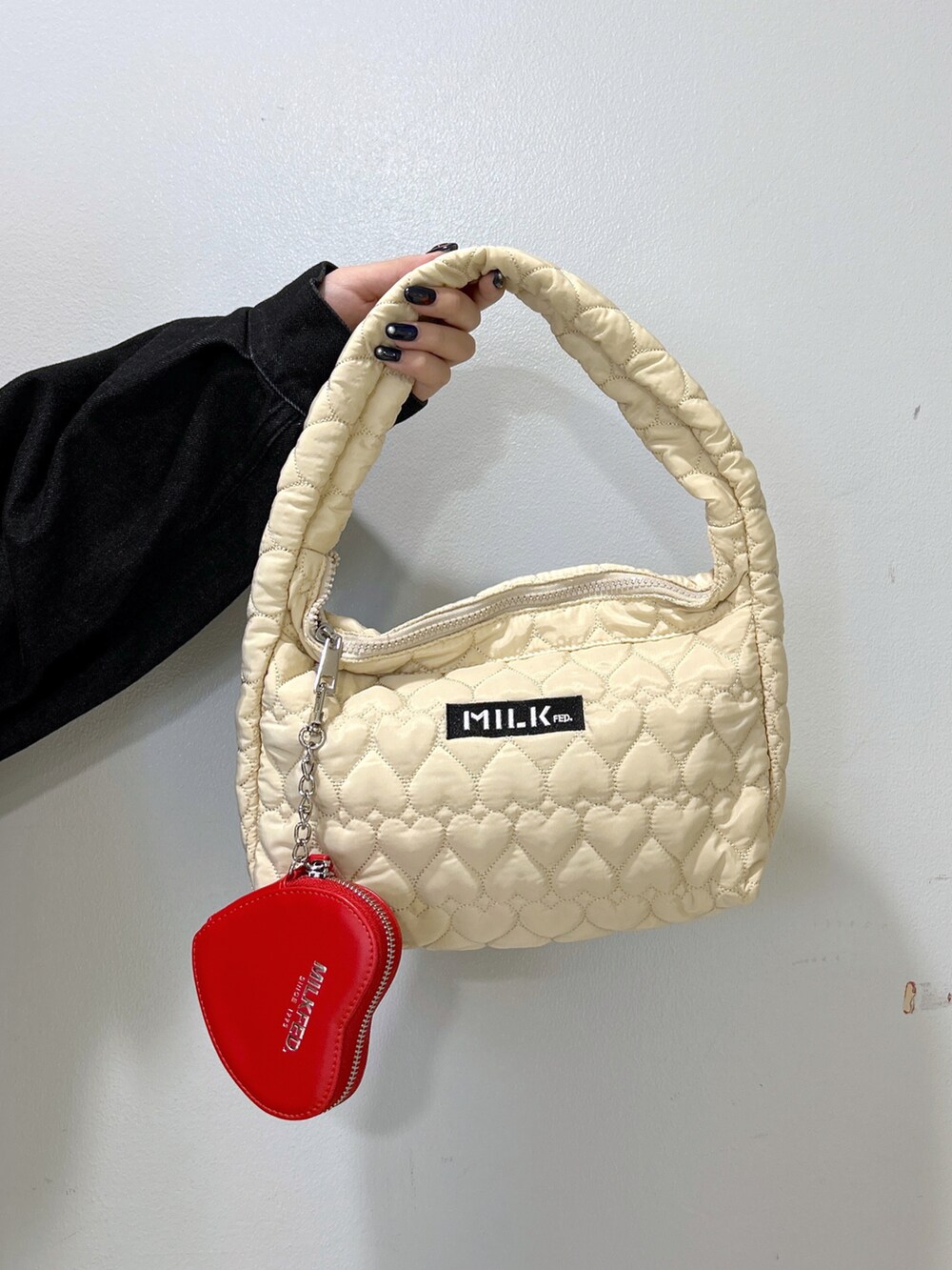 ブラック系のデニムジャケット、ブルー系のシャツワンピース、ホワイト系のハンドバッグを着用したレディースの秋コーディネートの4枚目の写真