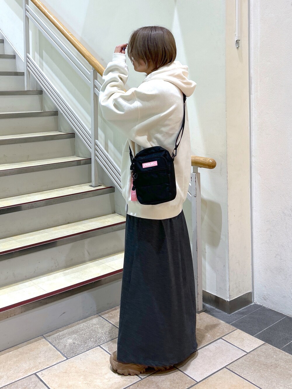 ホワイト系のパーカー、ピンク系のショルダーバッグ、グレー系のワンピースを着用したレディースの秋コーディネートの2枚目の写真