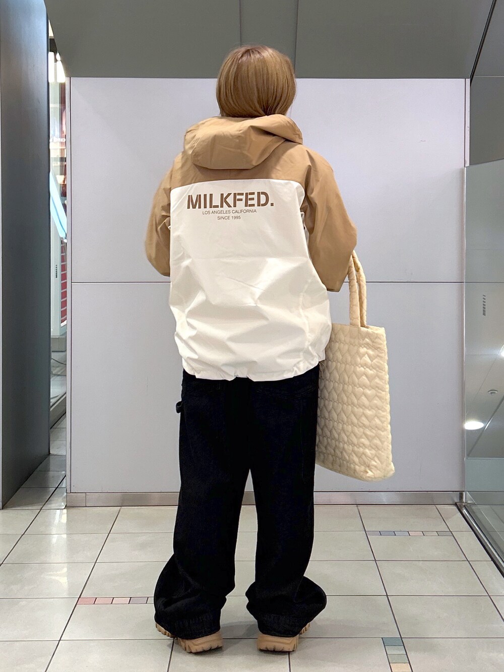 ベージュ系のマウンテンパーカー、ピンク系のニット/セーター、ブラック系のサロペット/オーバーオールを着用したレディースの秋コーディネートの2枚目の写真