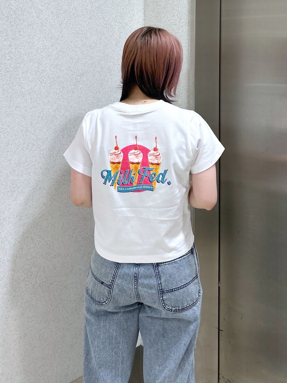 ブルー系のデニムパンツ、ピンク系のトートバッグ、ベージュ系のサンダルを着用したレディースの夏コーディネートの7枚目の写真