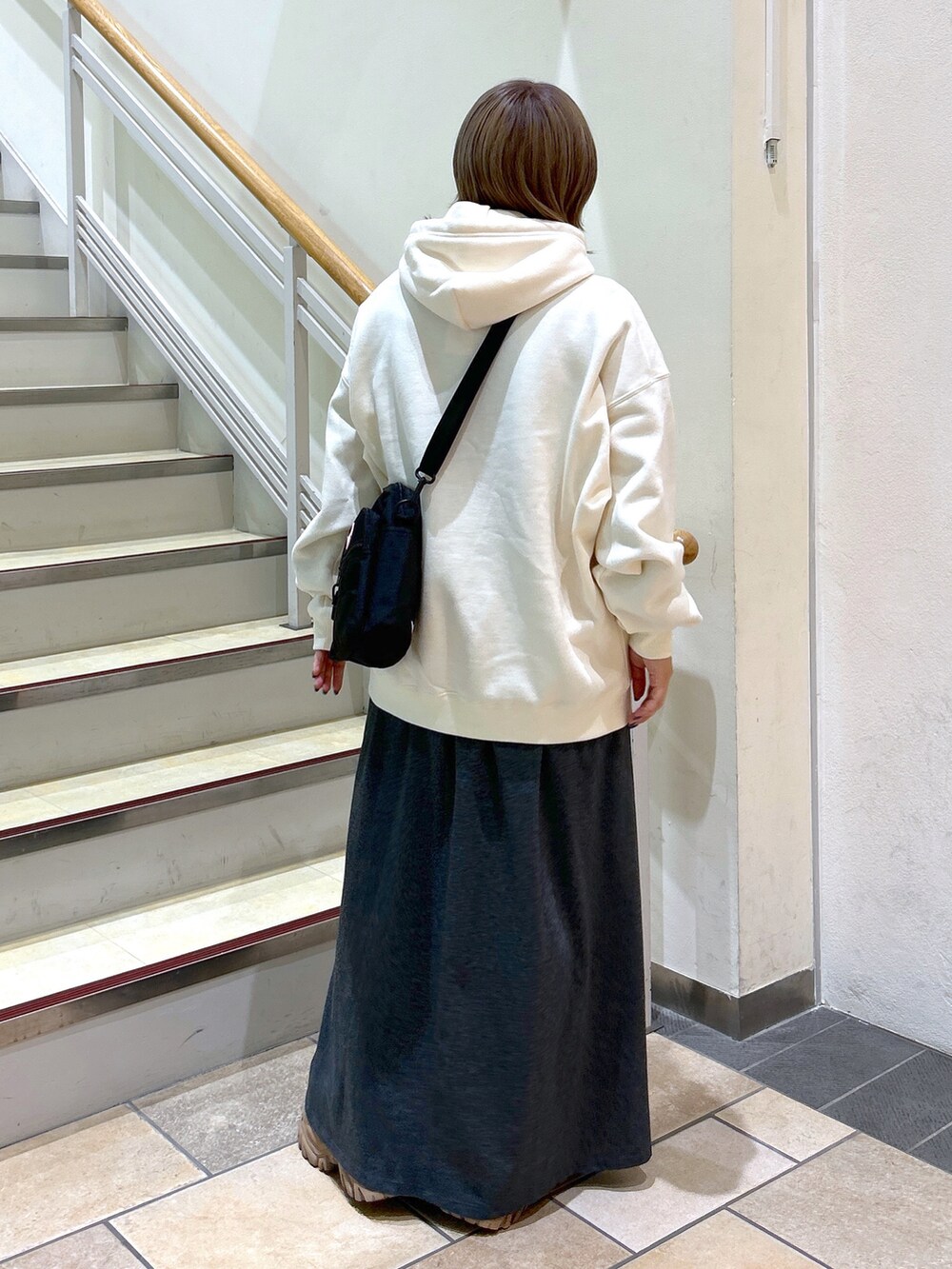 ホワイト系のパーカー、ピンク系のショルダーバッグ、グレー系のワンピースを着用したレディースの秋コーディネートの3枚目の写真