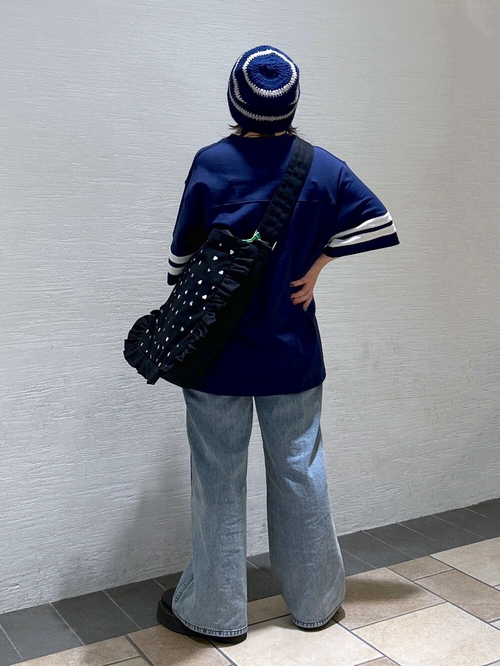 ブルー系のTシャツ/カットソー、ブルー系のデニムパンツ、ブラック系のブーツを着用したレディースの冬コーディネートの5枚目の写真