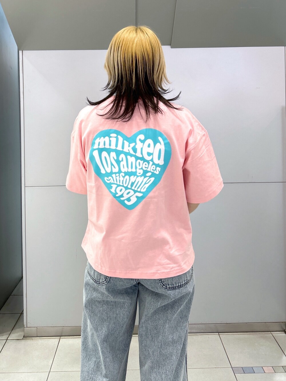 ピンク系のTシャツ/カットソー、ブルー系のデニムパンツ、ブラック系のショルダーバッグを着用したレディースの春コーディネートの6枚目の写真