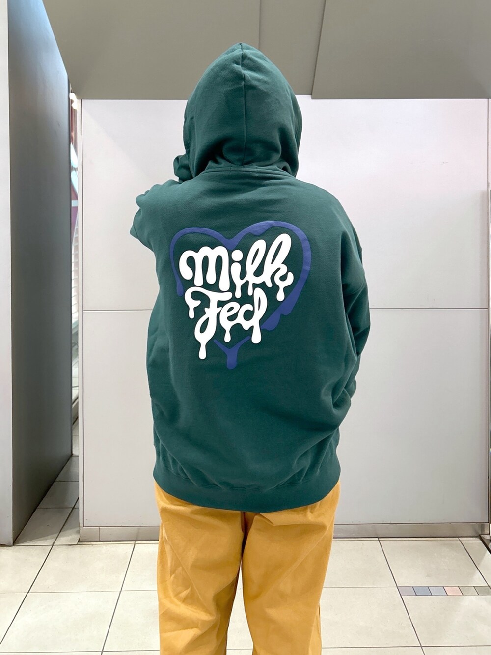 グリーン系のパーカー、ブラック系のTシャツ/カットソー、ベージュ系のサロペット/オーバーオールを着用したレディースの冬コーディネートの7枚目の写真