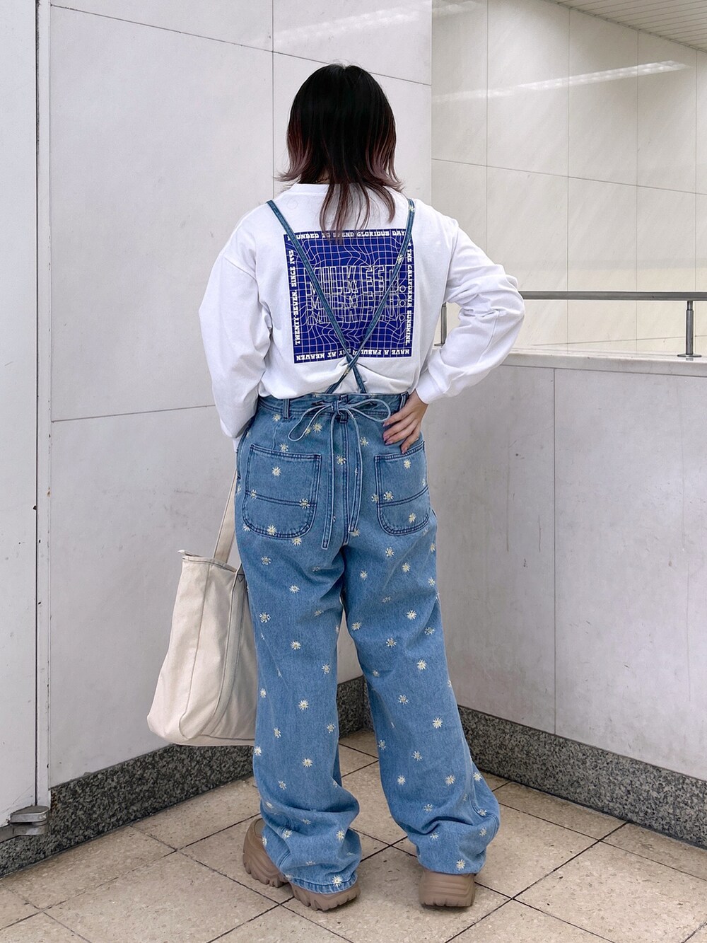 ホワイト系のTシャツ/カットソー、ブルー系のデニムパンツ、ブルー系のトートバッグを着用したレディースの秋コーディネートの3枚目の写真