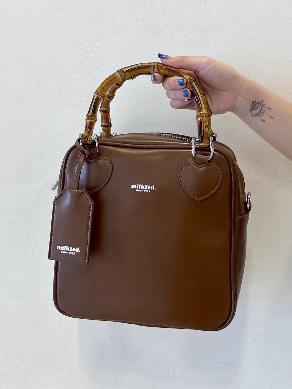 ブラック系のTシャツ/カットソー、ブルー系のワンピース、ブラウン系のショルダーバッグを着用したレディースの夏コーディネートの6枚目の写真