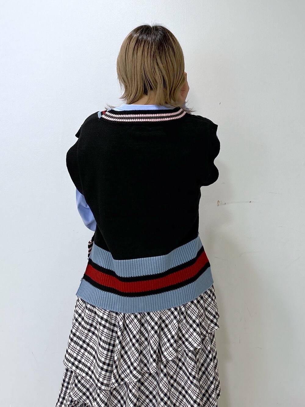 ブラック系のベスト、ブルー系のTシャツ/カットソー、ブラック系のスカートを着用したレディースの冬コーディネートの6枚目の写真