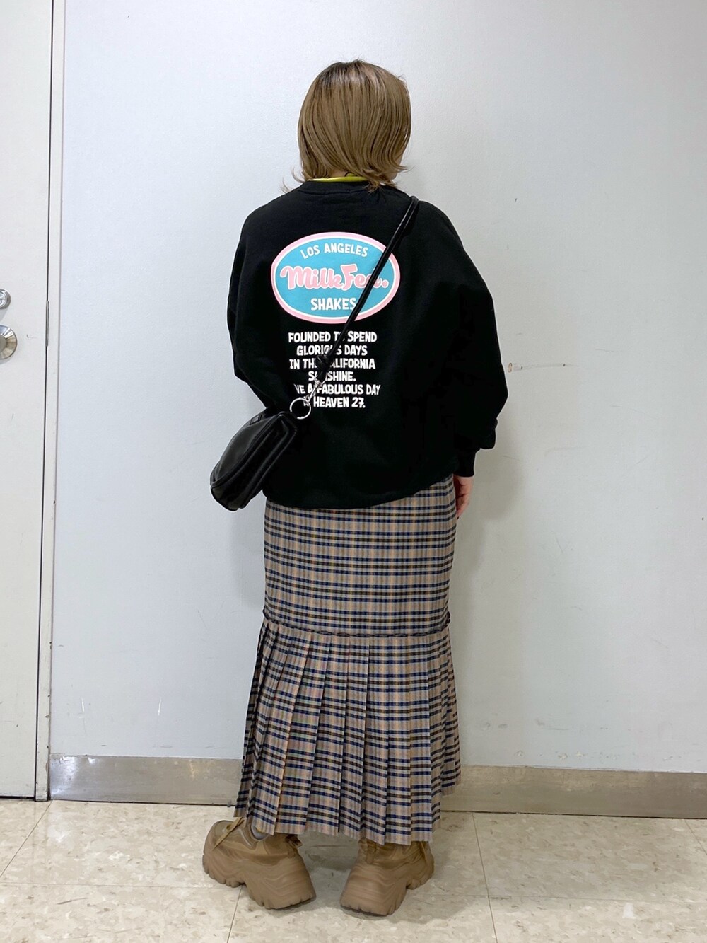 グリーン系のその他トップス、グレー系のスカート、ブラック系のショルダーバッグを着用したレディースの冬コーディネートの2枚目の写真