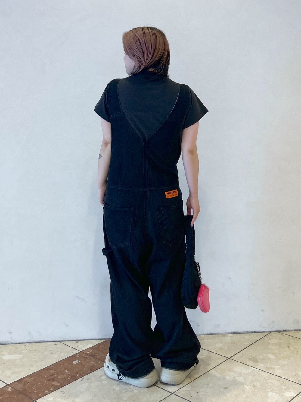 ブラック系のサロペット/オーバーオール、グレー系のTシャツ/カットソー、ベージュ系のサンダルを着用したレディースの夏コーディネートの4枚目の写真