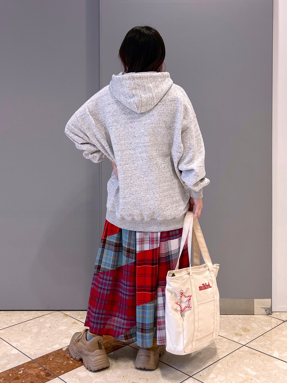 その他のパーカー、レッド系のスカート、レッド系のトートバッグを着用したレディースの秋コーディネートの2枚目の写真