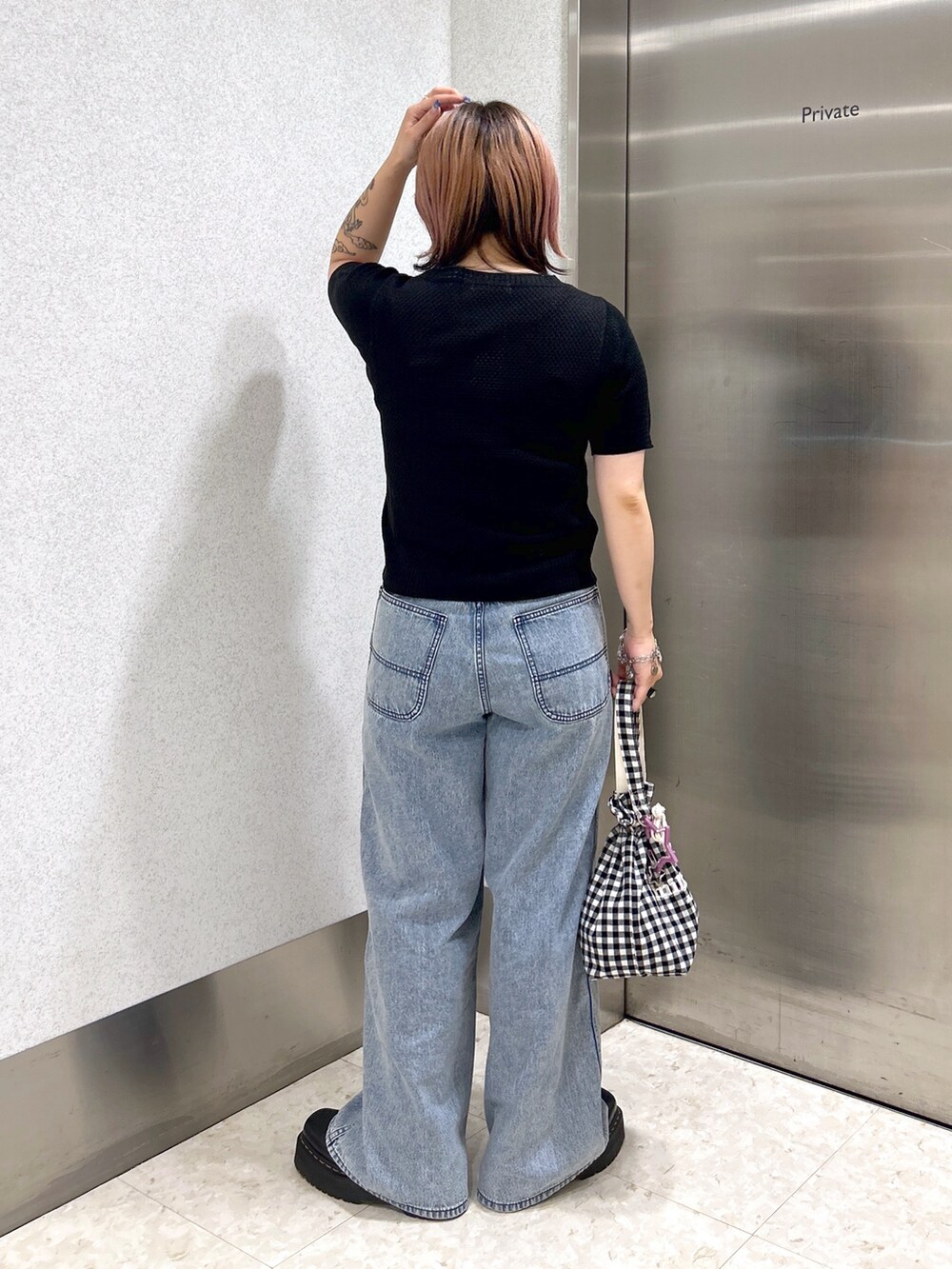 ブルー系のデニムパンツ、パープル系のタンクトップ、ブラック系のカーディガン/ボレロを着用したレディースの夏コーディネートの4枚目の写真