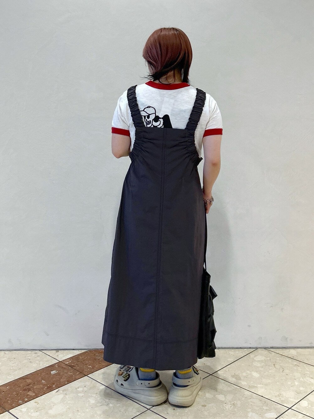 レッド系のTシャツ/カットソー、ベージュ系のサンダル、ブラック系のトートバッグを着用したレディースの春コーディネートの5枚目の写真