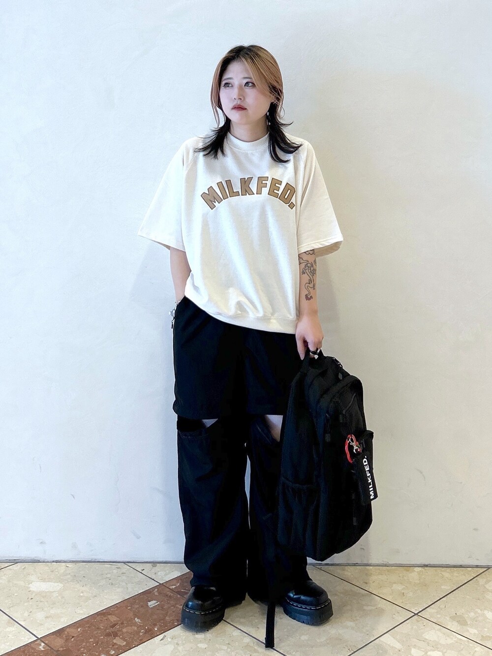 ブラック系のその他パンツ、ブラック系のブーツ、ホワイト系のTシャツ/カットソーを着用したレディースの夏コーディネートの2枚目の写真