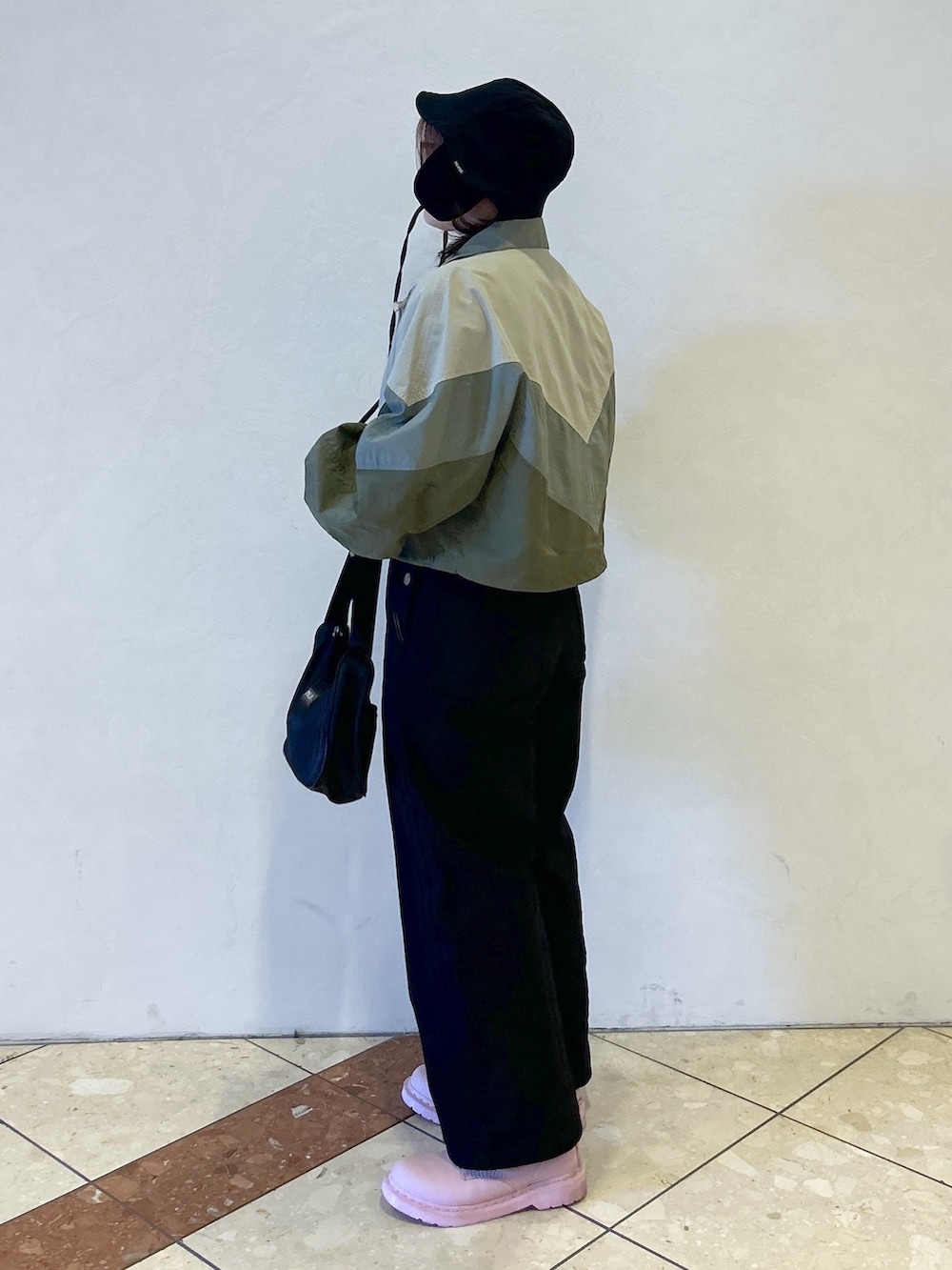 グレー系のTシャツ/カットソー、ベージュ系のナイロンジャケット、ブラック系のサロペット/オーバーオールを着用したレディースの春コーディネートの4枚目の写真