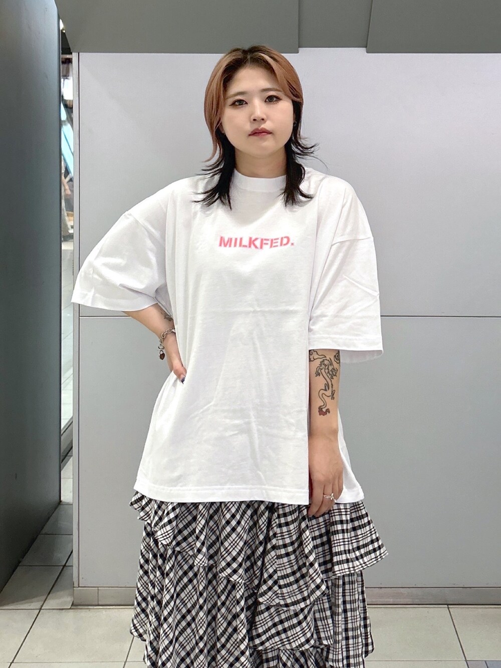 ホワイト系のTシャツ/カットソー、ブラック系のスカート、ベージュ系のサンダルを着用したレディースの夏コーディネートの4枚目の写真