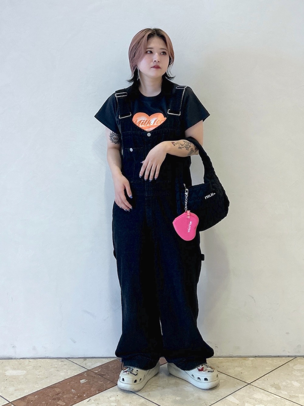 ブラック系のサロペット/オーバーオール、グレー系のTシャツ/カットソー、ベージュ系のサンダルを着用したレディースの夏コーディネートの3枚目の写真