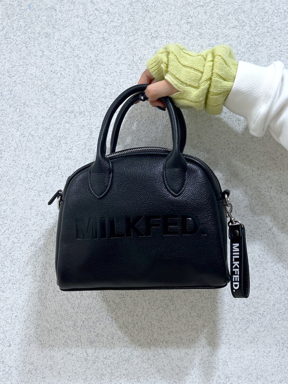 ブラック系のベスト、ホワイト系のスウェット、ブラック系のボストンバッグを着用したレディースの秋コーディネートの4枚目の写真