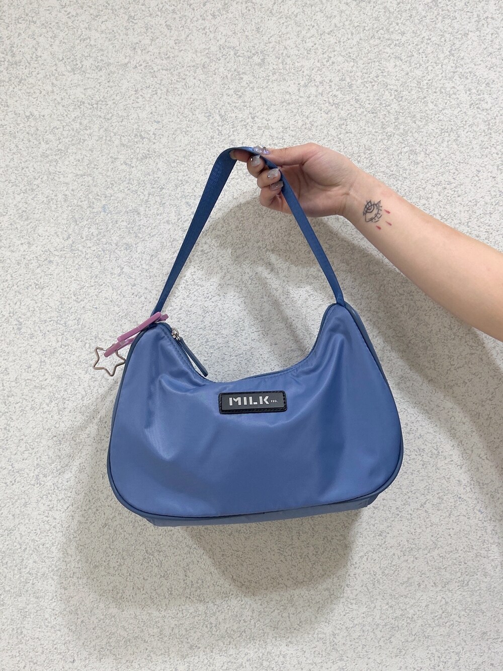 ブラック系のTシャツ/カットソー、ブルー系のデニムスカート、ブルー系のハンドバッグを着用したレディースの春コーディネートの5枚目の写真