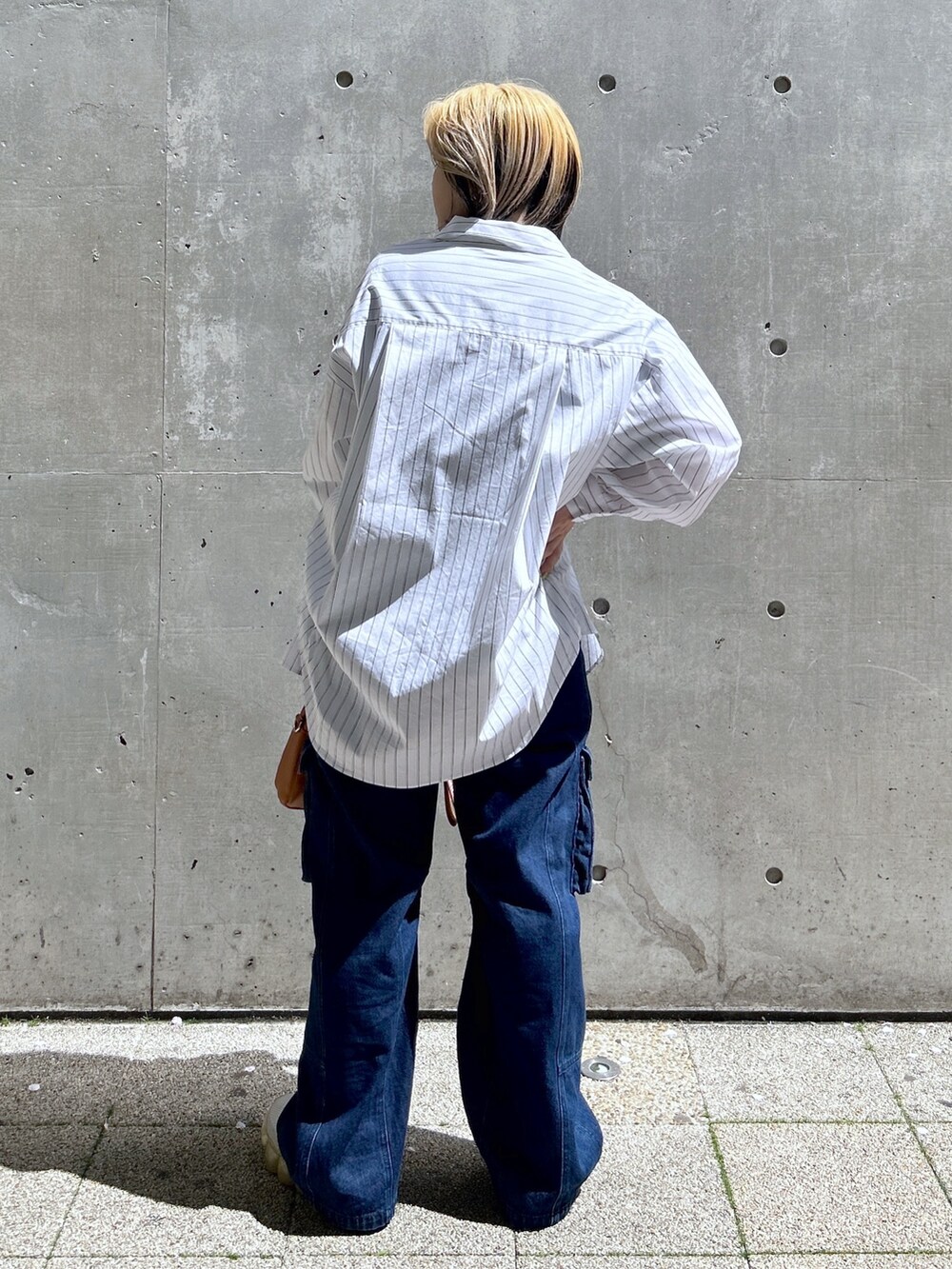 ブルー系のTシャツ/カットソー、ブラウン系のボストンバッグ、ブルー系のカーゴパンツを着用したレディースの春コーディネートの4枚目の写真