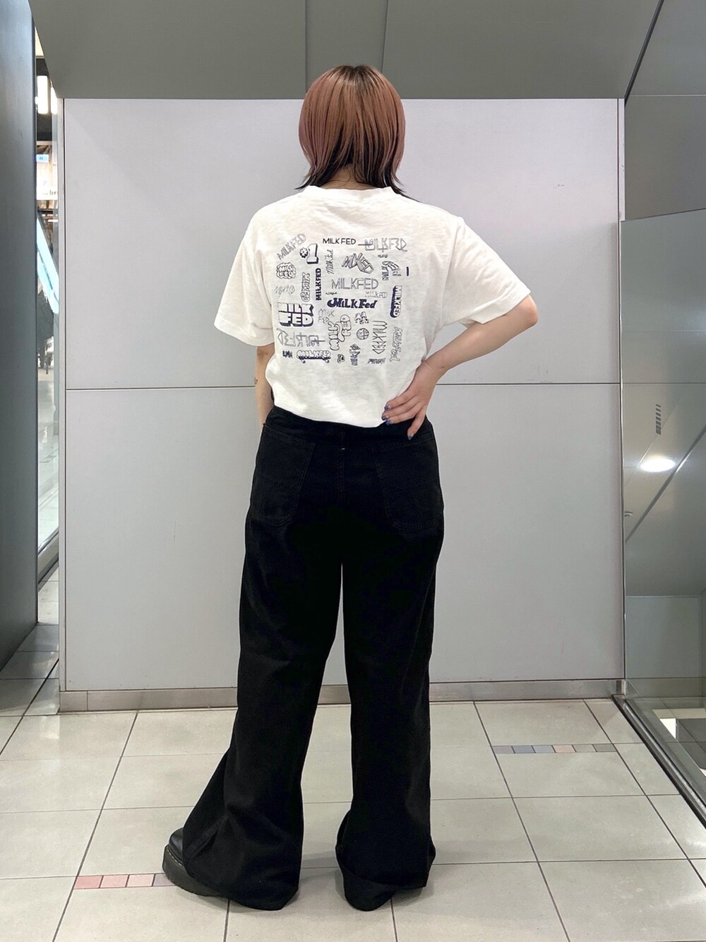 ブラック系のブーツ、ホワイト系のTシャツ/カットソー、ブラック系のデニムパンツを着用したレディースの夏コーディネートの3枚目の写真