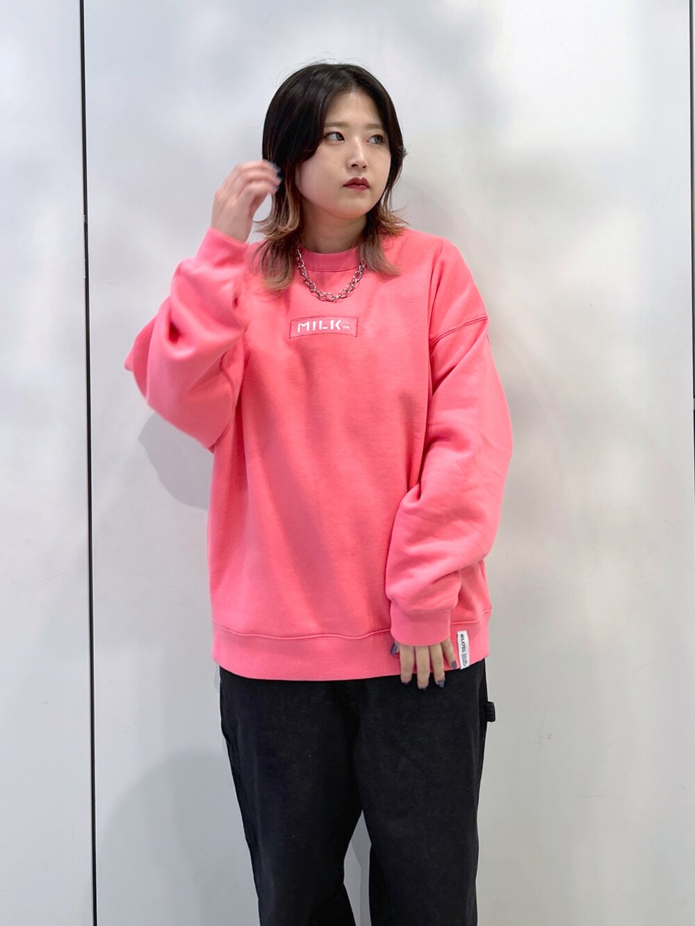 ピンク系のスウェット、ブラック系のサロペット/オーバーオール、ベージュ系のスニーカーを着用したレディースの秋コーディネートの4枚目の写真