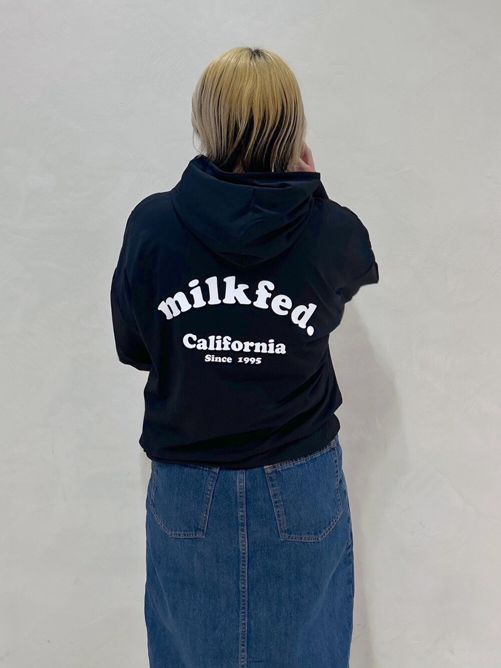 ブルー系のデニムスカート、ピンク系のショルダーバッグ、ホワイト系のTシャツ/カットソーを着用したレディースの春コーディネートの7枚目の写真