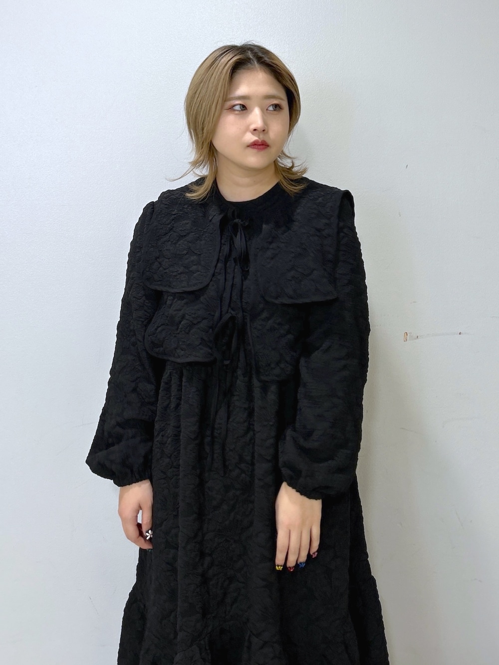 ブラック系のワンピース、パープル系のショルダーバッグ、ベージュ系のスニーカーを着用したレディースの冬コーディネートの3枚目の写真