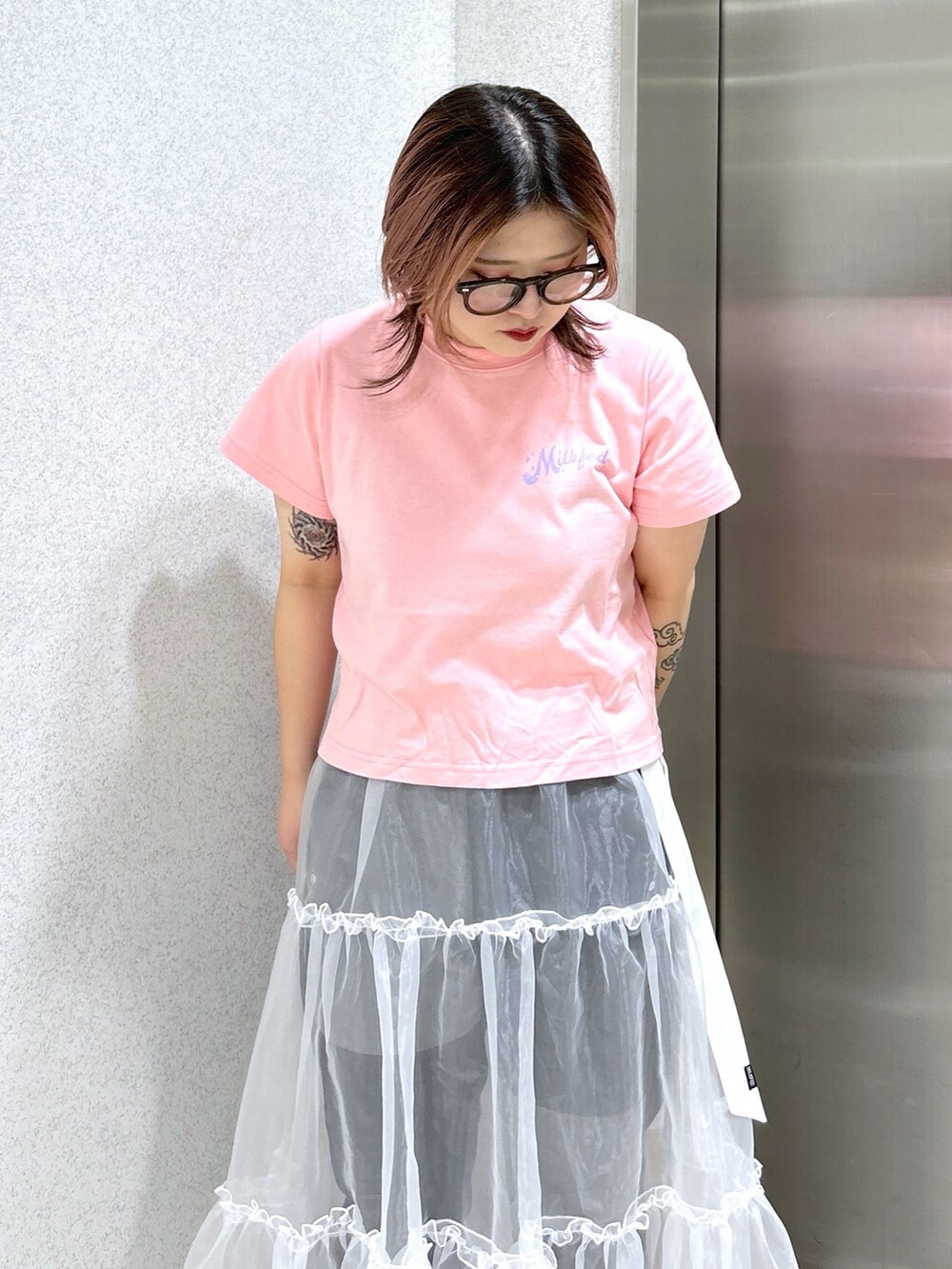 ピンク系のTシャツ/カットソー、ブラック系のデニムパンツ、ホワイト系のスカートを着用したレディースの春コーディネートの4枚目の写真