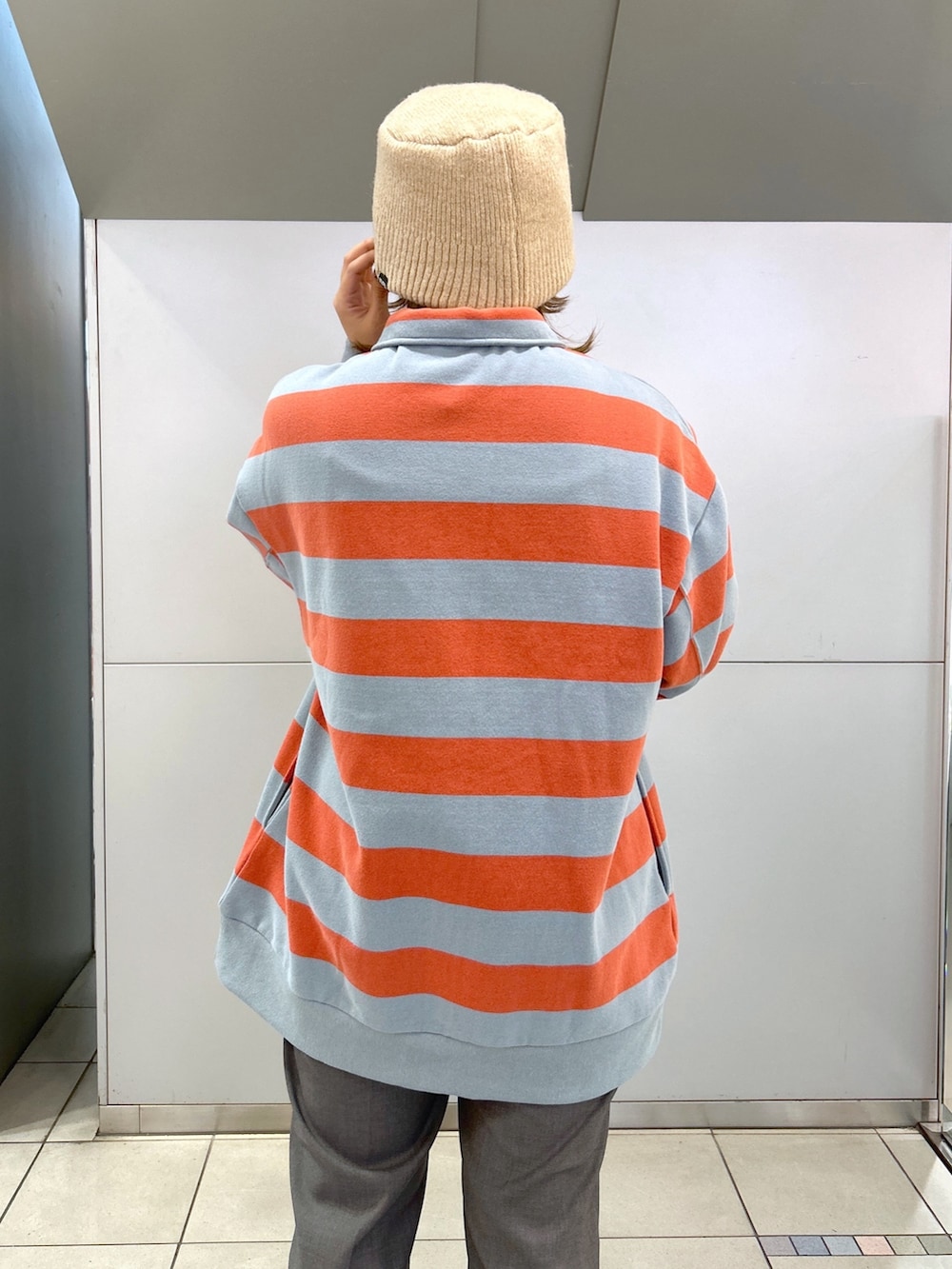 ホワイト系のベスト、ベージュ系のスニーカー、ピンク系のスウェットを着用したレディースの冬コーディネートの4枚目の写真