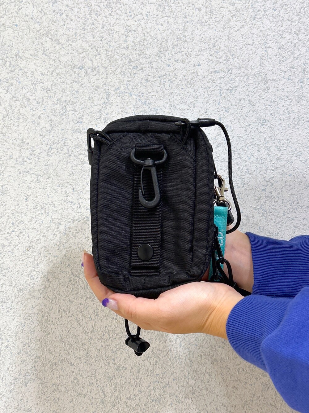 ブルー系のスウェット、ブルー系のスカート、ベージュ系のスニーカーを着用したレディースの秋コーディネートの5枚目の写真