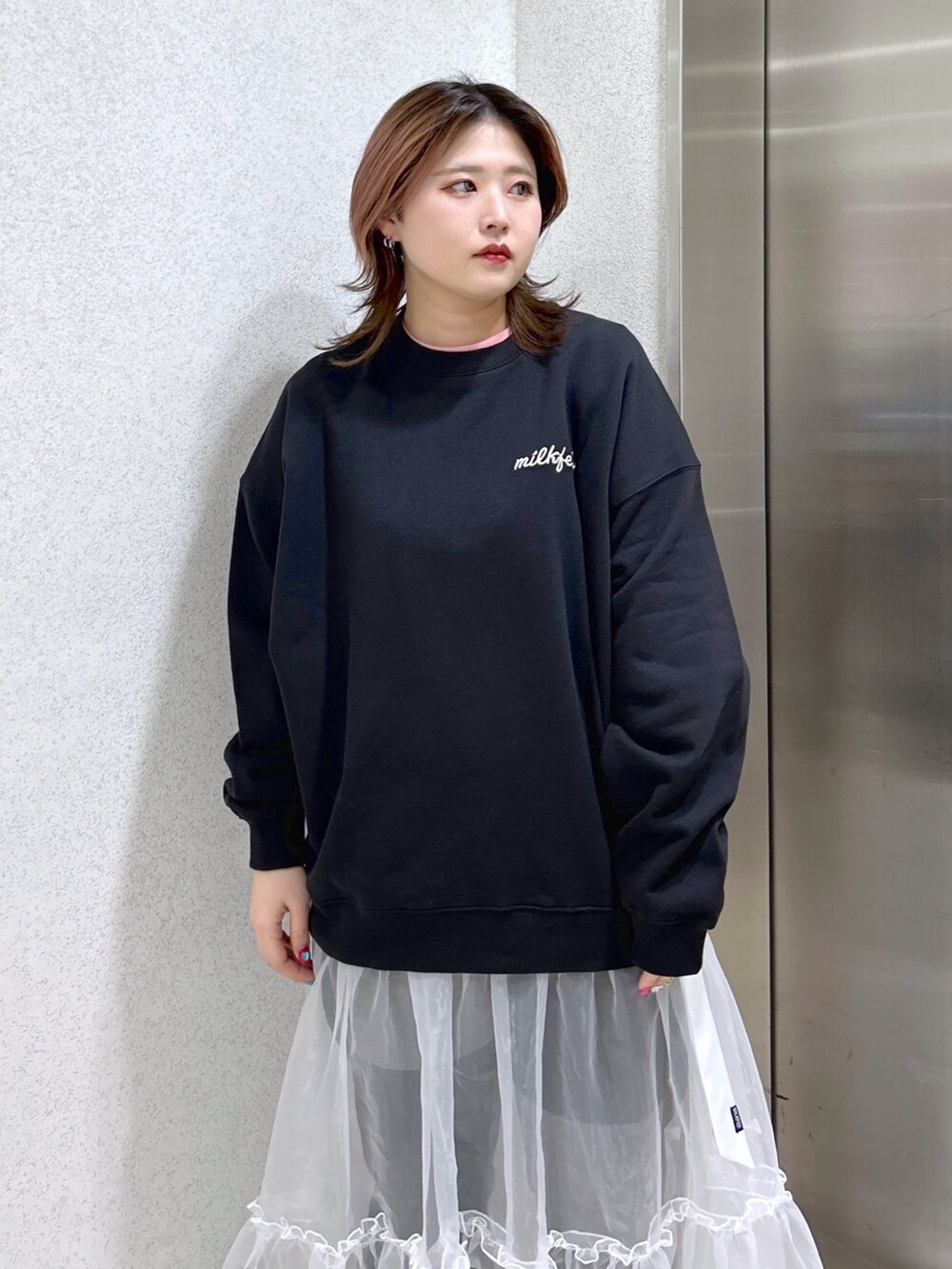 ブラック系のスウェット、ピンク系のショルダーバッグ、ブラック系のブーツを着用したレディースの春コーディネートの4枚目の写真