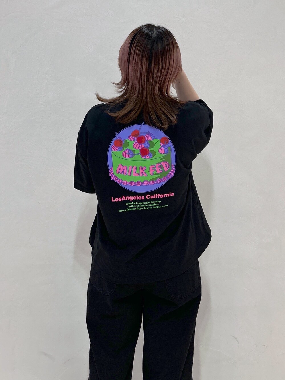 ブラック系のTシャツ/カットソー、ブルー系のハンドバッグ、ブラック系のブーツを着用したレディースの春コーディネートの4枚目の写真
