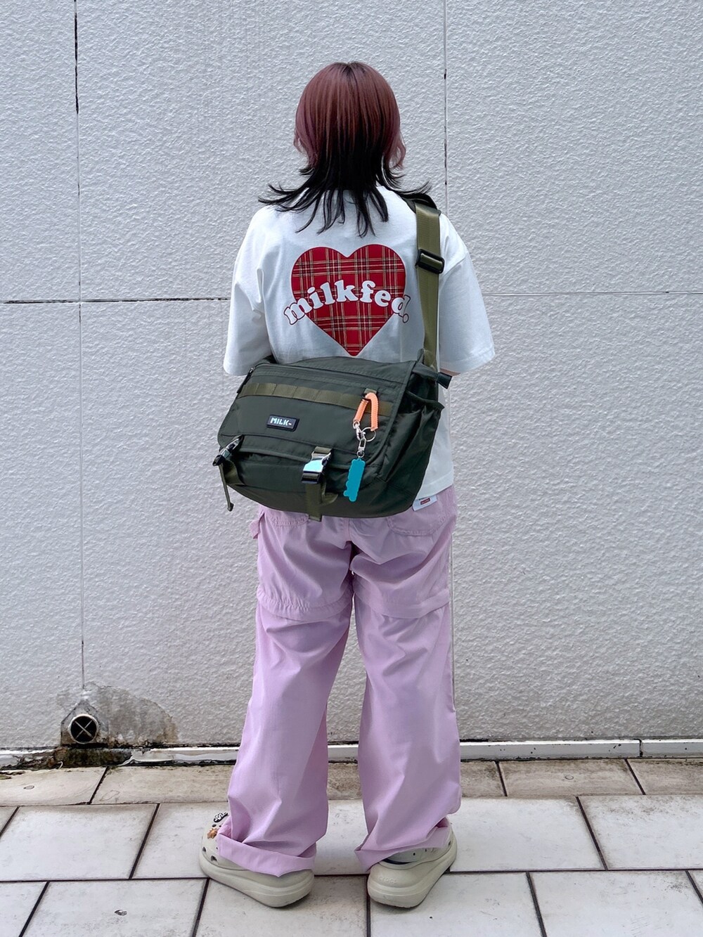 ピンク系のその他パンツ、グリーン系のメッセンジャーバッグ、ホワイト系のTシャツ/カットソーを着用したレディースの春コーディネートの3枚目の写真